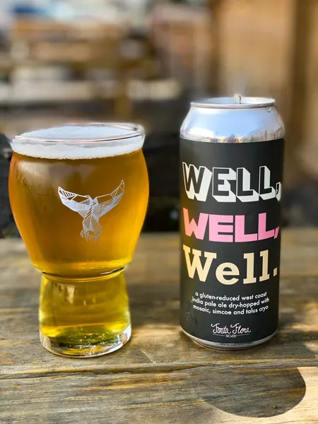 The Whale Beer in West Asheville with glass oof amber gluten free beer next to can that says 'well. well. well.'