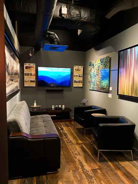 Walls Wine Bar Downtown Asheville NC gallery room with two black chairs and a black couch with art on walls