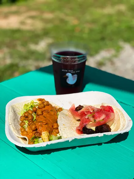 White Duck Taco Asheville NC with picture of two tacos and local craft cider on green picnic table