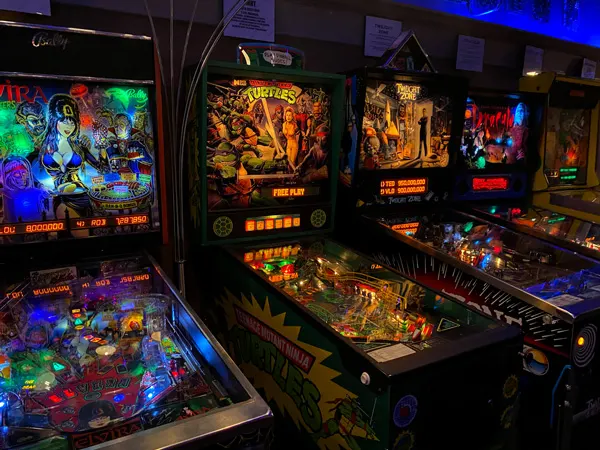 Appalachian Pinball Museum Hendersonville NC with dark room filled with lighted pinball arcade gaming machines