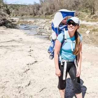 Tori Curran Explore With Tori white woman with long dirty blonde hair in light blue shirt with baby in hiking pack on back