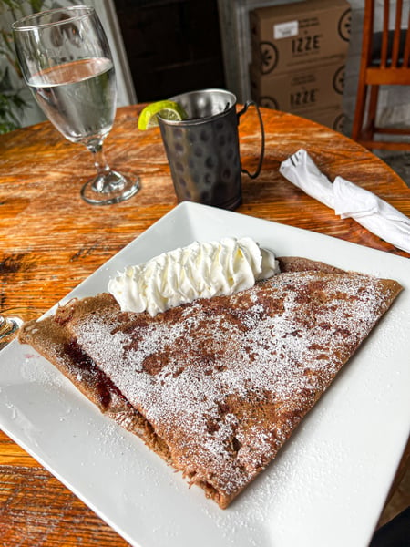Cecilia's Kitchen in Asheville, NC Gluten free crepe on plate with sugar, jelly filling and whipped cream