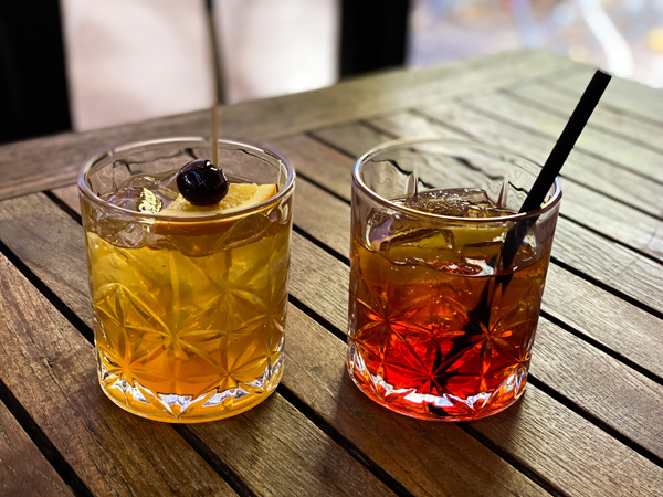 Cocktails at Corner Kitchen Asheville NC Brunch with light yellow cocktail and darker red cocktail on table  