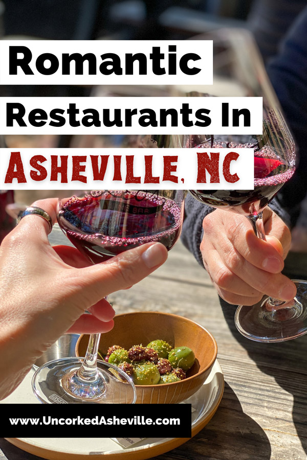 Intimate Date Night Restaurants In Asheville NC Pinterest pin with red wine glasses doing a cheers over table with green olives
