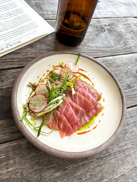 Yellowfin Tuna on white plate with veggies and oil at Leos House Of Thirst in Asheville, NC