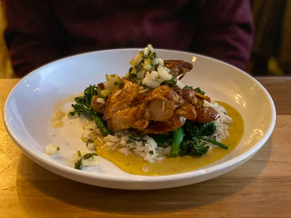 Limones Restaurant Asheville NC with plate of chicken on rice with thick yellow sauce