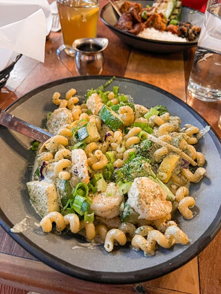 Bowl of pasta with shrimp and green vegetables on table at Nine Mile restaurant in Asheville, NC (Montford location)