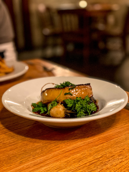 The Bull and Beggar Asheville foie gras in a white bowl and garnished with herbs