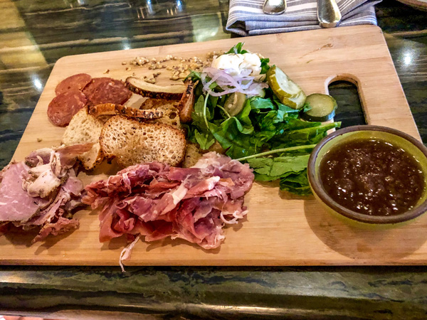Chestnut Charcuterie Board Asheville NC with jam, meats, bread, and greens