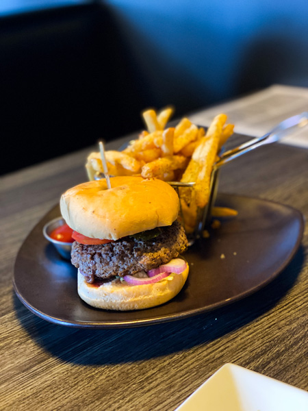 The Madness Asheville Burger on plate with french fries and ketchup