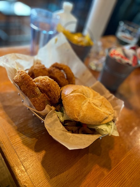 Vegan Farm Burger in Asheville NC with burger in basket with golden brown onion rings