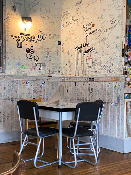 12 Bones Smokehouse River Arts District Asheville Restaurant with picture of table and chairs with writing all over walls