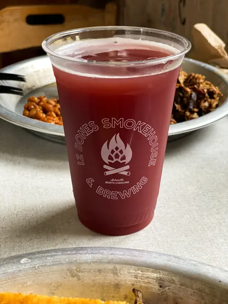 12 Bones Smokehouse River Arts District Restaurant with red colored beer in front of plate of BBQ