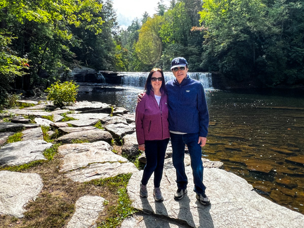 Man and woman in front of Hooker Falls waterfall