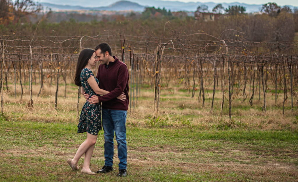 Featured Article, Romantic Things To Do In Asheville For Couples, image with Christine and Tom - a white brunette male and female - embraced in winery vineyard