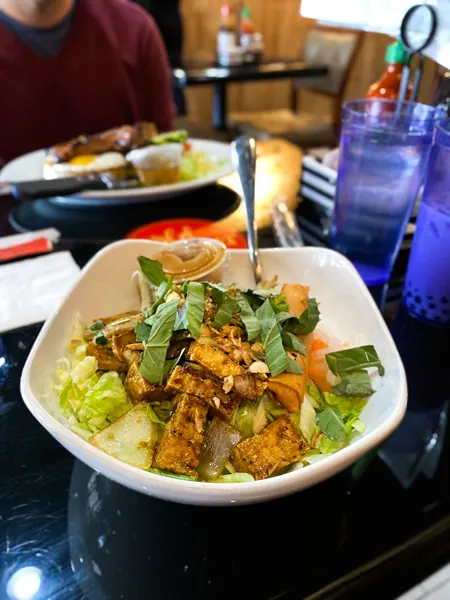 Wild Ginger Noodle Bar Restaurant Asheville NC with white bowl filled with rice vermicelli, tofu, lettuce, and veggies