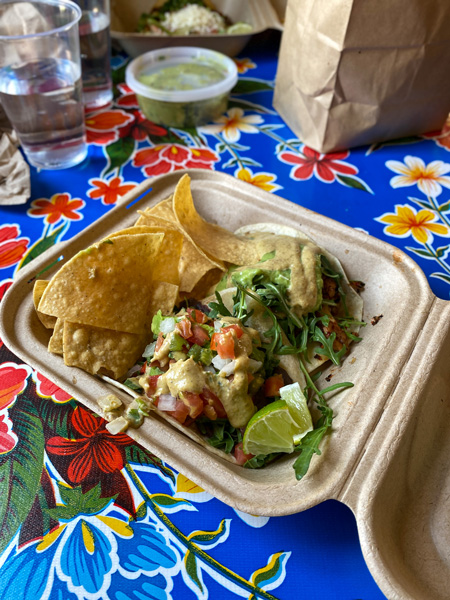 Mamacita's Taco Temple vegan tacos Asheville NC with two tacos in to-go container on table with chips and guacamole