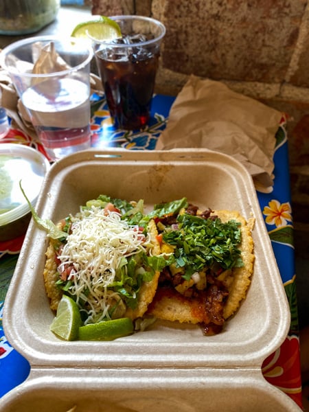 Mamacita's Taco Temple gluten free tacos in Asheville with two corn tortilla tacos in a to-go container on table