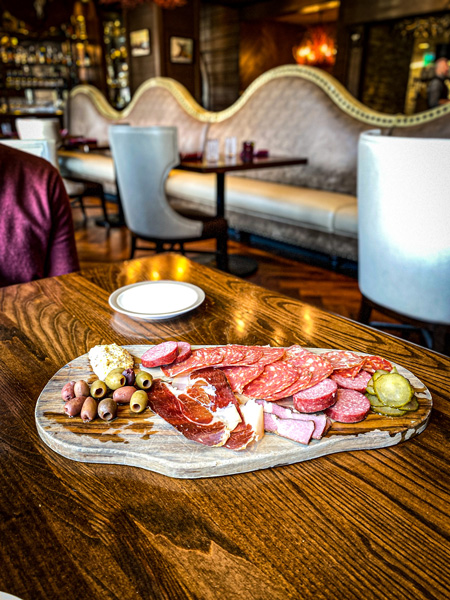 Charcuterie board with cured meats, olives, pickles, and Lusty Monk Mustard at the Red Stag Grill in Asheville, NC