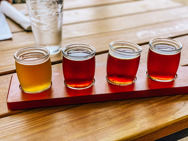 Rye Knot Restaurant Distillery Brewery Asheville NC with flight of 4 beer glasses mostly amber in color with one yellow beer