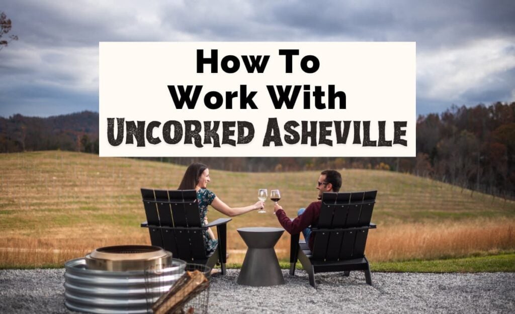 Work with Uncorked Asheville with white brunette male and woman sitting in chairs overlooking Marked Tree Vineyards with red and white glass on wine and doing a cheers