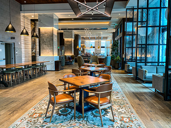 District 42 Downtown Asheville Bar with fancy brown tables, modern lighting, and gray and orange-brown patterned rug