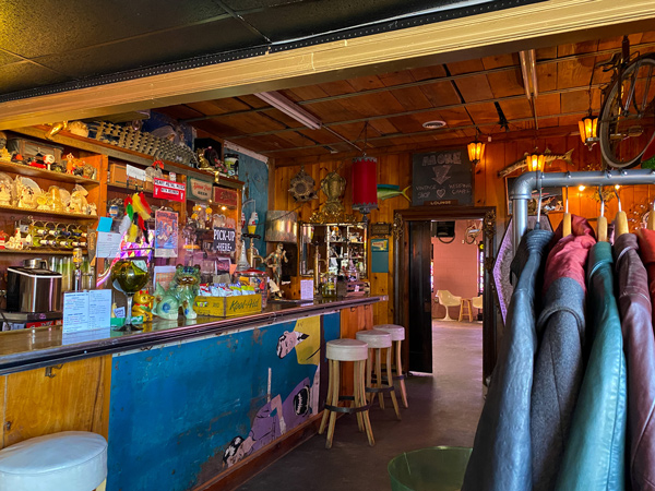 Fleetwood's Chapel Bar Asheville with three white bar stools at colorful and busy looking bar