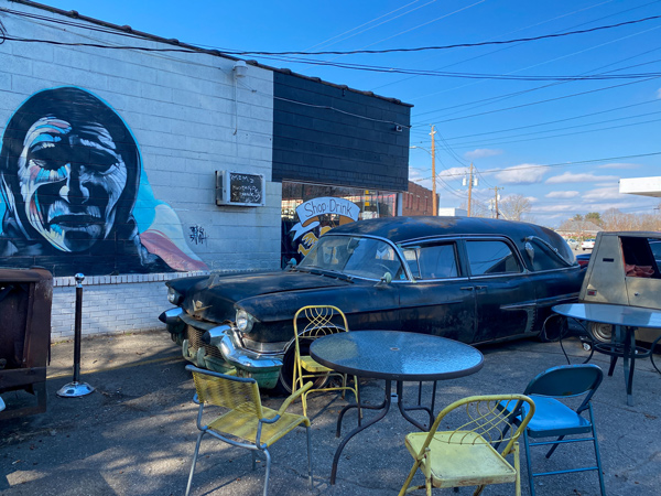 Fleetwoods Chapel West Asheville with black hearse outside with table and chairs