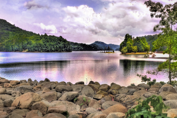 Lake Glenville Western North Carolina Mountains with rocks leading up to gray water with purple cloudy sky