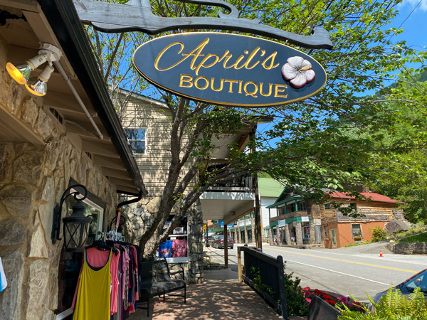 Chimney Rock Village NC Main Street with sign for April's boutique along paved two lane road with clothes outside and other shops around it