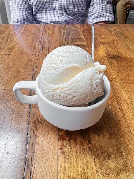 French Broad Chocolate Lounge Vegan Ice Cream Asheville in white coffee cup on brown table