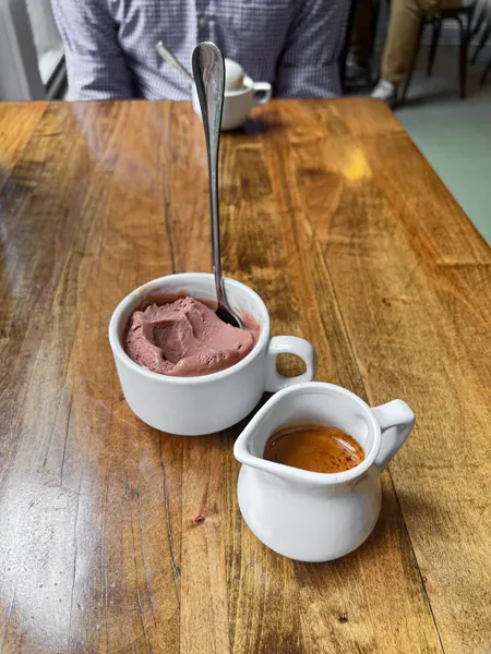 French Broad Chocolate Vegan Affogato Coffee Asheville with small white dish with espresso next to coffee cup with vegan chocolate ice cream with spoon in it