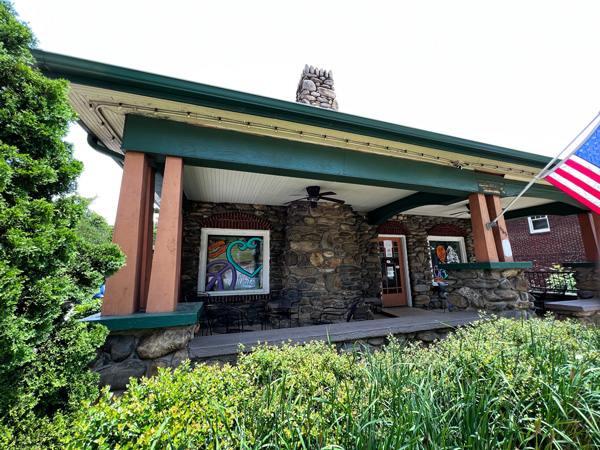 Whit's Frozen Custard Asheville NC building with American flag, stone fireplace, and colorful pictures on windows