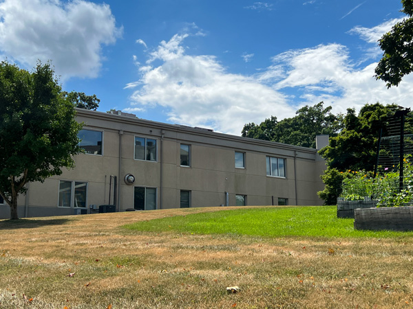 Former Highland Hospital Asheville NC site with green gray and two floor gray concrete building