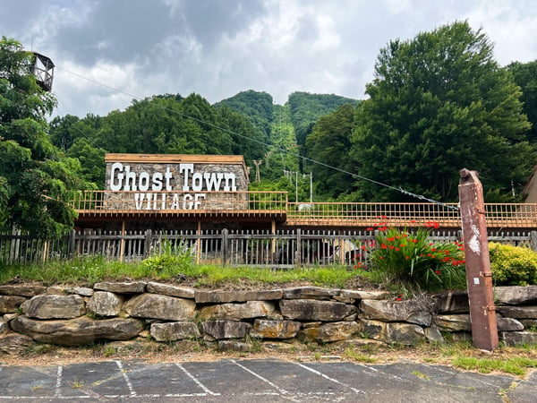 Ghost Town in the Sky Maggie Valley NC with image of parking lot and building that says Ghost Town with lift up into the mountains