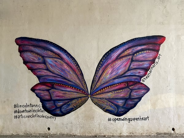 Lincolnton NC Wings Mural with purple and pink butterfly wings on white wall