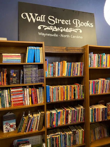 Wall Street Books Waynesville NC with three bookshelves filled with colorful books