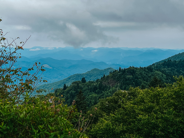 Blue Ridge Parkway Sylva Maggie Valley NC with blue and green mountains with gray clouds and trees