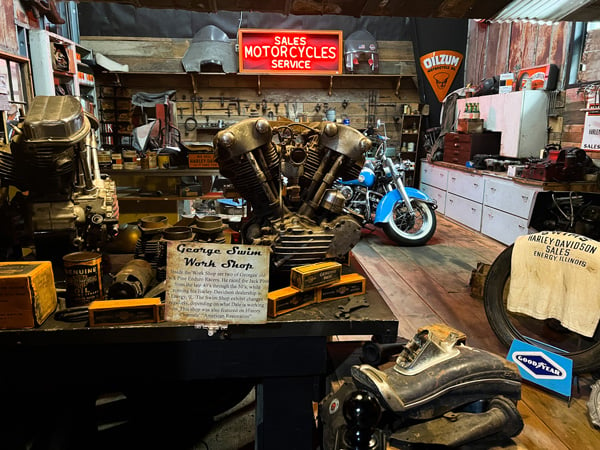 Wheels Through Time Museum Maggie Valley North Carolina old workshop exhibit with sign and antique motorcycle parts