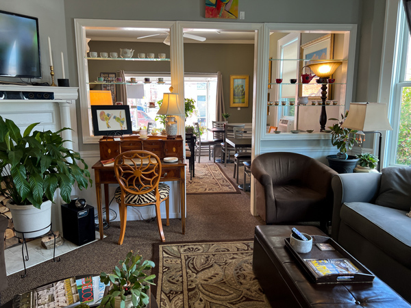Art & Coffee Bar On 5th Hendersonville North Carolina with two small rooms with rugs and couch, desk, and chair seating