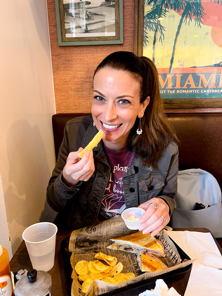Christine eating Cousins Cuban Cafe Cuban sandwich