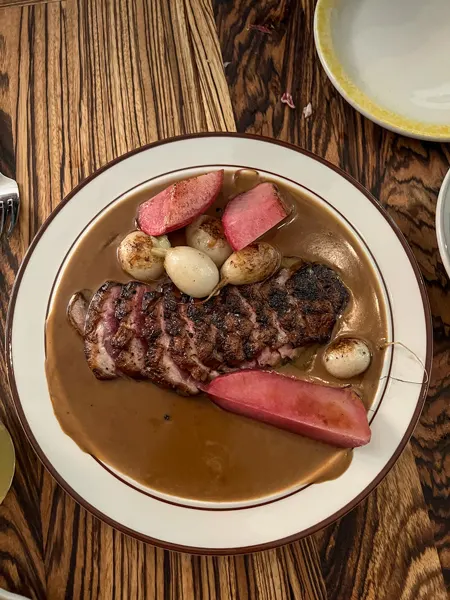 Neng Js Restaurant Asheville NC with plate of duck in gravy with red radishes on table