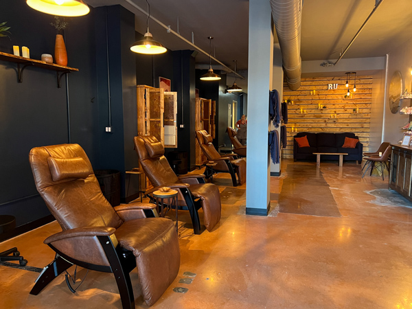 Recline & Unwind Social Spa in Asheville NC with empty recliners against a blue wall for massage services