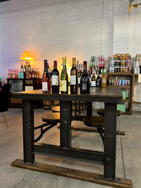 Saint Brighids Bar Marquee Asheville North Carolina with white bottles lined up on brown table in bar seating area