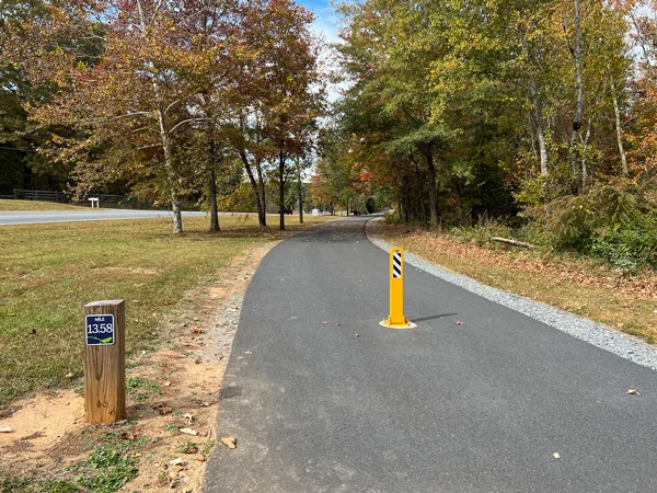 Thermal Belt Rail Trail North Carolina with paved and flat trail with yellow post to divide sides and mile marker
