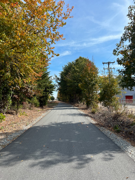 Thermal Belt Rail Trail Spindale NC with paved flat trail surrounded by green and fall foliage trees