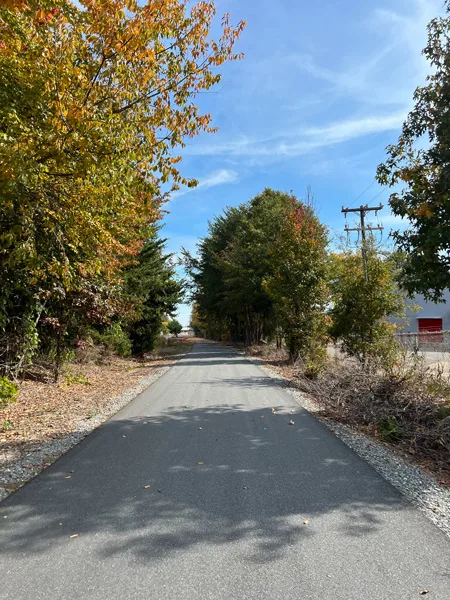 Thermal Belt Rail Trail Spindale NC with paved flat trail surrounded by green and fall foliage trees