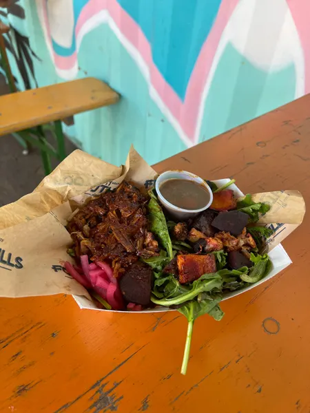 Foothills Food Truck At Hi Wire Beer Garden Asheville NC with image of pulled pork BBQ on salad in throw-away bowl on table with mural in background