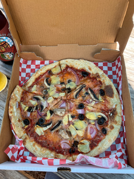 Tin Can Pizzeria Food Truck Asheville NC with pizza with no cheese, mushrooms, onions, and olives in to-go box