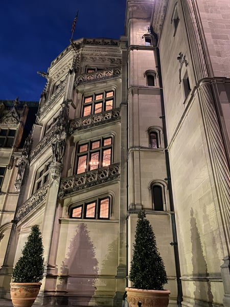 Biltmore House Facade in Asheville, North Carolina with gray exterior with tiny lit windows going up three stories